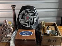 Overview with heater, bookends, vase, boxes, frames, cup in crate