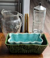 Group shot showing both ceramic planters, glass pitcher, Barbicide jar and easel