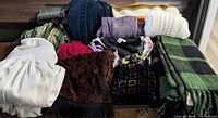 Overall lot with blankets, clothing and accessories on trunk