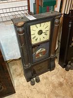 Front view showing full clock, dial, glass panels, two weights