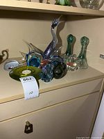 Group shot of all art glass pieces on cabinet shelf