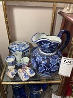 Shelf view with large floral pitcher, candy dish, egg cups, creamer, clogs, saucer