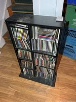 full view of black CD rack filled with discs