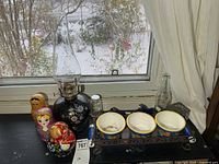 Oil lamp, nesting dolls, planters set on tray, blue bottle, shaker and brush on shelf