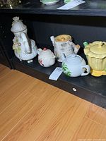 Shelf view showing all five ceramic teapots