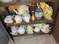 Two shelves showing entire assortment of teapots and brass vase