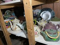 Shelf showing multiple teapots and excluded plates