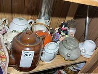 Shelf showing multiple teapots in various colors and styles