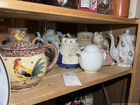 Shelf showing six assorted teapots