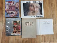 All five art books laid out on wood floor