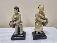 Both figurines side by side on bases