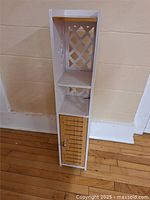 Full view of narrow white cabinet with bamboo door