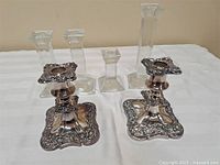 Overview of two metal candlesticks and four glass holders