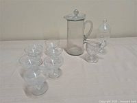 Group shot showing all glass pieces: pitcher, jar, creamer, six coupes