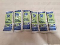 Front view of six sealed DCT 9-84 delimer packets