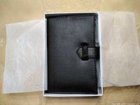 Address book in open gift box, showing black cover and crystal tab