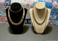 Four necklaces on display stands showing styles and shine