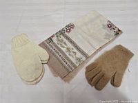 Full view of mittens, gloves and scarf laid out