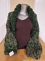 Full view of hand-knitted shrug on mannequin