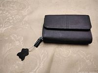 Exterior view of closed brown leather wallet with zip pull