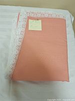 Folded peach tablecloth with lace border
