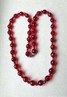 Full view of red crystal necklace laid in loop