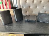 Two AR surround speakers, Bose component, AR subwoofer on table