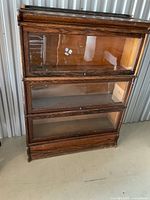 Full front view of three-section wooden barrister bookcase with glass doors