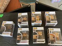 Group shot of seven boxed Funko POP! Television figures on table