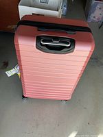 Front view of pink hard-side suitcase with recessed handle and wheels