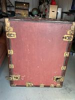 Front view of maroon Pathfinder trunk with brass hardware