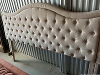 Front view of beige tufted headboard showing overall style and condition