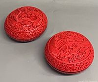 Both cinnabar boxes top view showing dragon and landscape carvings