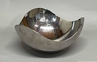Side view of stainless steel bowl displaying wavy rim and reflective finish
