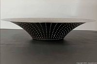 Side profile showing flared shape and perforations