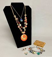 Lot overview on display bust showing both necklaces, cufflinks, ring, bracelet and case