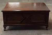 Front view of cedar chest showing carved panels and feet