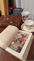Overview showing both books open, teacup, saucer and lion mug