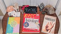 Full lot overview showing all books, crystals and hand figurines on table