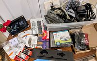 Overview of lot showing bin of cables, boxed electronics, media packs and accessories