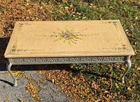 Full view of coffee table outdoors showing top and metal base