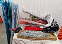 Tall bundle of metallic blue reeds and box with assorted glitter stems and peacock feather