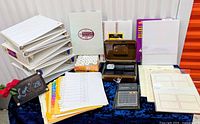 overview of lot showing binders, cash box, calculator, paper rolls, file folders, business card sheet packs