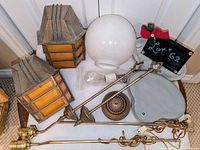 Group shot of sconces, lamp bases, globe shade, brass posts and hardware