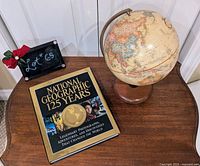 Globe and book displayed on wooden table