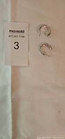 pair of patterned silver hoop earrings beside MaxSold lot card