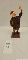Front view of Simpich newsboy figurine on base
