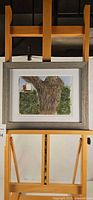 Front view of framed watercolor painting on easel