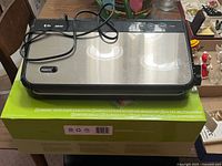 Top view of FoodSaver FM2900 vacuum sealer resting on retail box with power cord visible