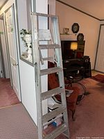 Full view of aluminum step ladder standing upright